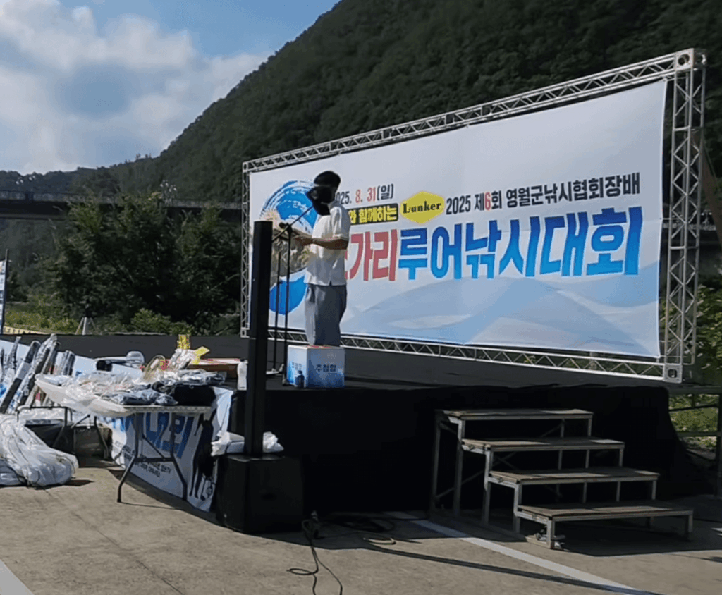 영월쏘가리낚시대회 무대 전경, 현수막과 시상 준비물이 배경