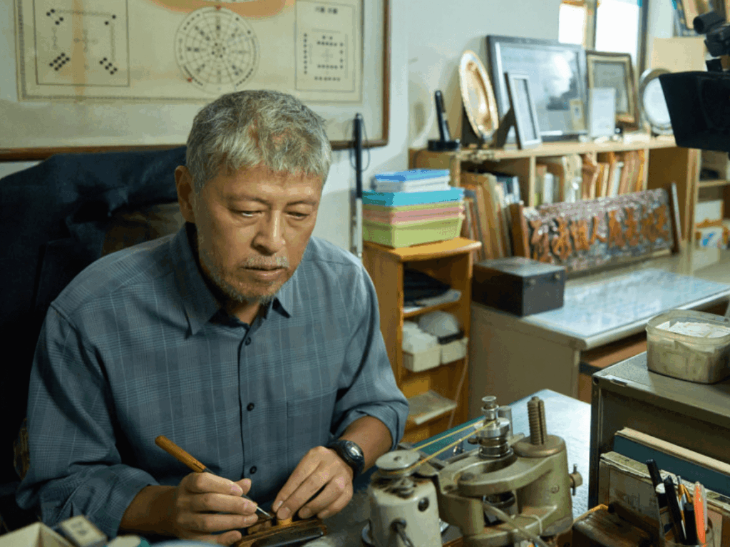 작업실에서 정밀 기계를 다루는 노년의 남자 모습