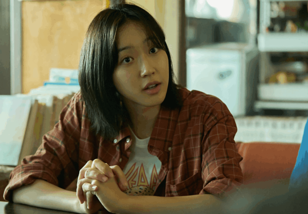 붉은 체크 셔츠를 입은 젊은 여성이 대화를 나누는 모습