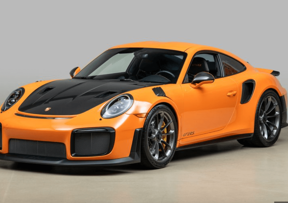 “주황색 포르쉐 911 GT2 RS 스포츠카가 실내 전시장에 전시된 모습”